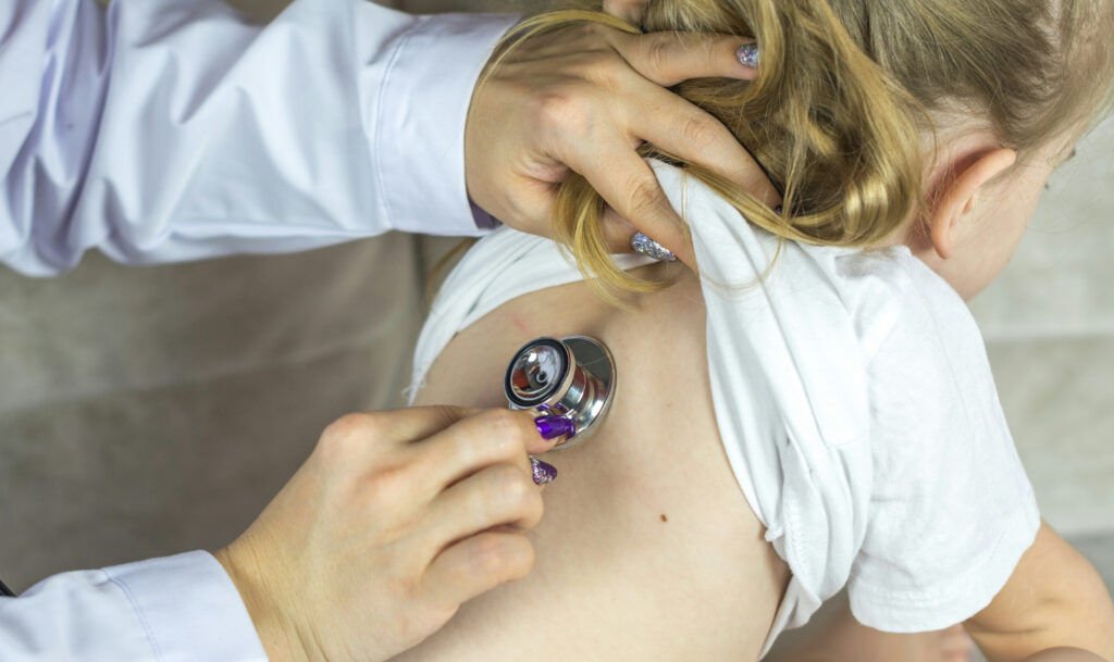 Doctor with stethoscope on child's back