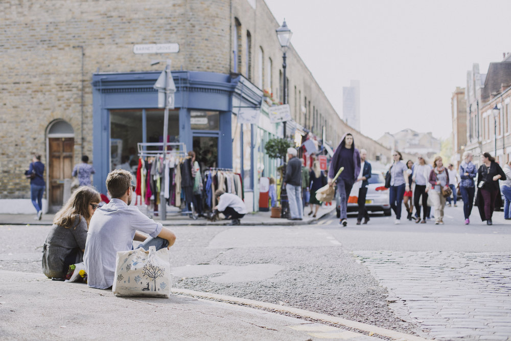 people walking on street and sitting on kerb